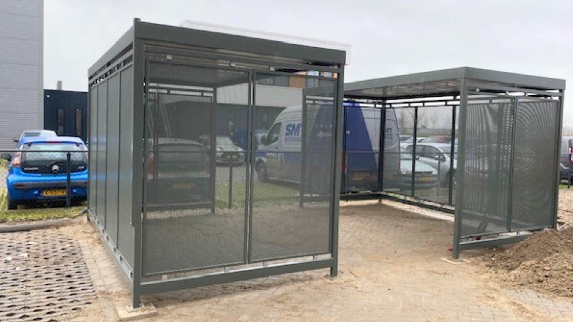 Twee fietsoverkappingen van geperforeerd staal in antracietkleur