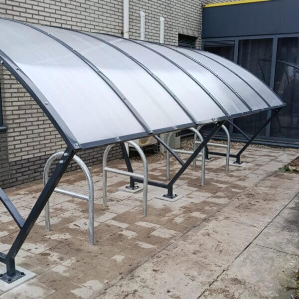 Fietsoverkapping voor stallen van fietsen aanschaffen Fietsoverkapping van 5 meter in RAL 7016 antraciet geleverd in Woerden met gebogen polycarbonaat dak en stalen fietsbeugels