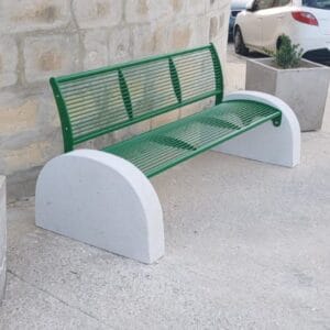 Groene stalen parkbank met betonnen poten geplaatst op een plein.