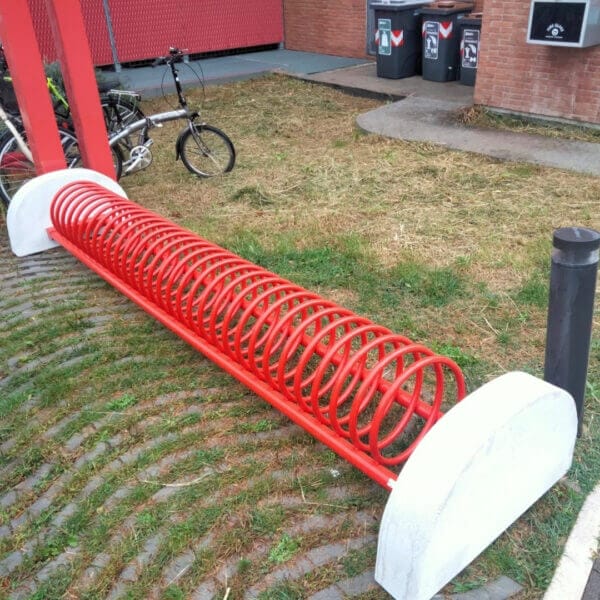 Fietsenrek in spiraalvorm met rode coating en betonvoet