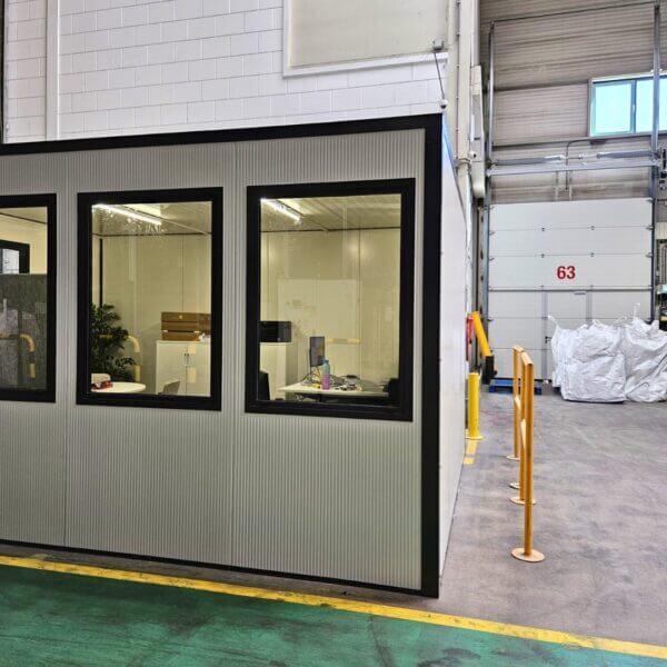 Kantoorunit voor binnen kopen Binnenzijde van een modulaire kantoorunit met ramen en zicht op bureaus en kantoormeubilair in een hal.