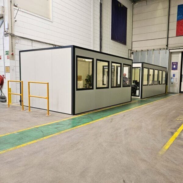 Modulaire-kantoorunit-voor-binnen-kopen-aanschaffen Modulaire kantoorunit van 4x3 meter met ramen, geplaatst in een industriële hal voor extra werkruimte.