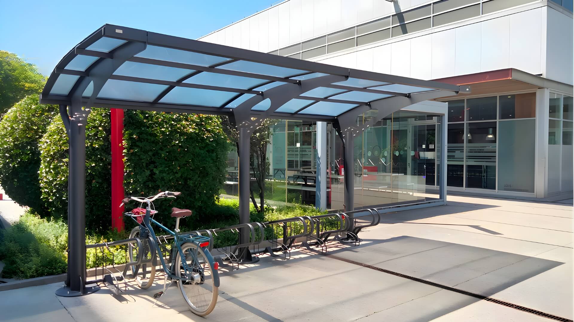 Rijwieloverkapping van 5 meter, van staal en polycarbonaat, kleur antraciet en stevig verankerd op beton.