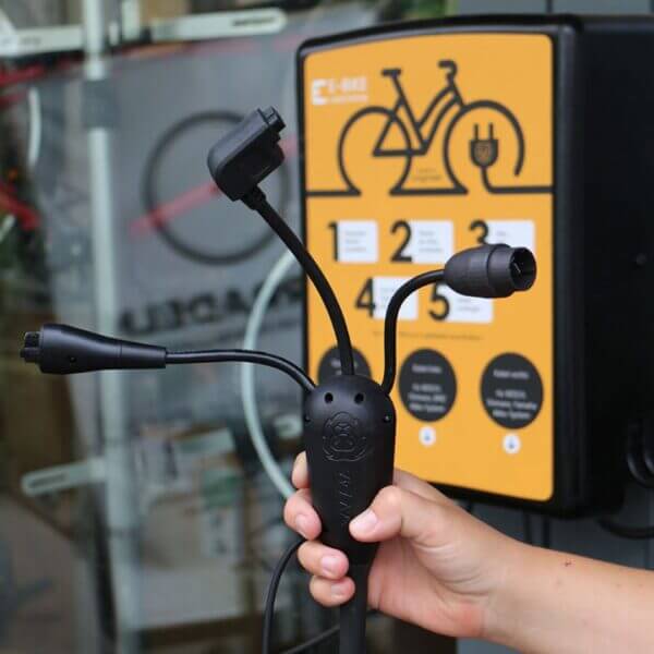 Laadstation voor elektrische fietsen met meerdere oplaadkabels en wandmontage-optie.