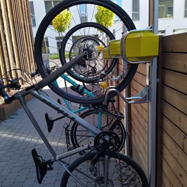 openbaar-parkeren-fietsrekken-parkis Fietsen verticaal geparkeerd in gele muurbeugels buiten