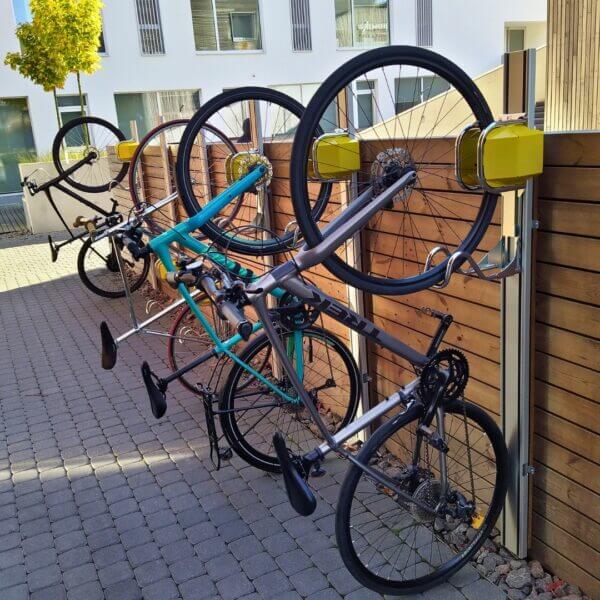 Meerdere fietsen geplaatst in verticale muurrekken buiten