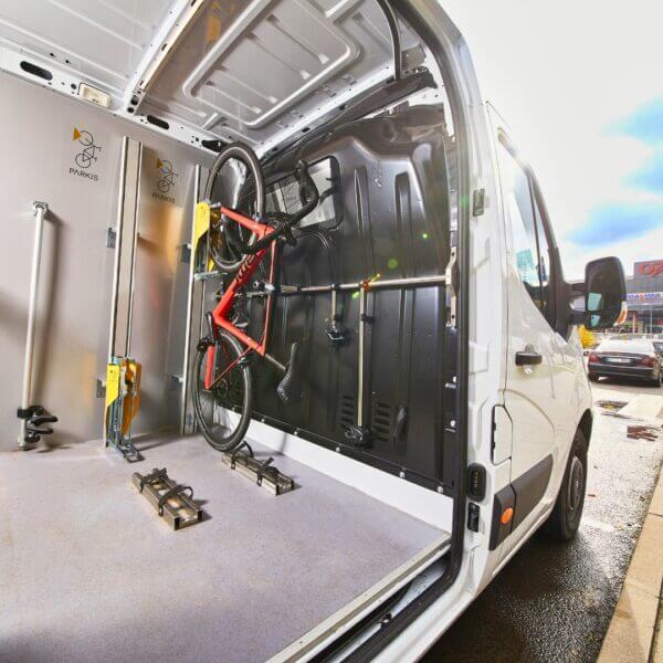 Verticaal fietsenrek voor montage in bus Verticaal fietsenrek met lift gemonteerd in bestelbus, geschikt voor veilig transport van fietsen
