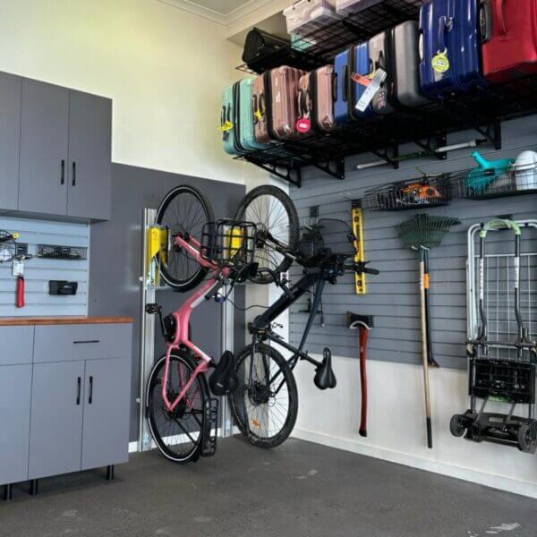 verticaal-fietsenrek-fiets-opslag-garage Fietsen opgehangen aan muur in garage met verticale fietsrekken