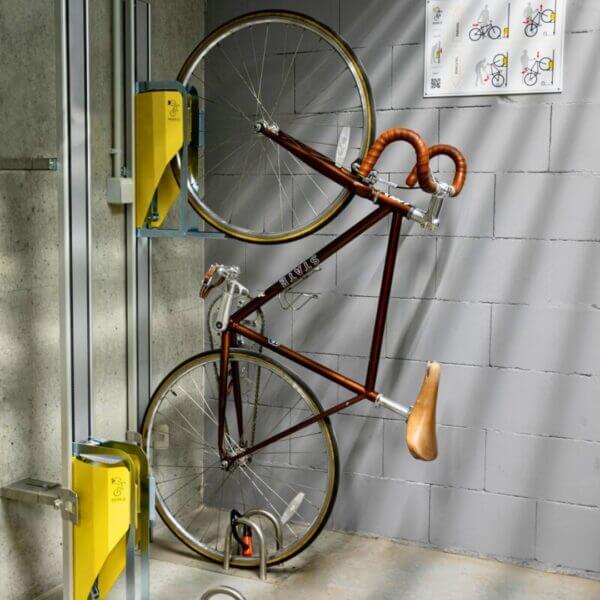 verticaal-fietsenrek-indoor-opslag Racefiets aan een verticale fietsenrek met muurbevestiging