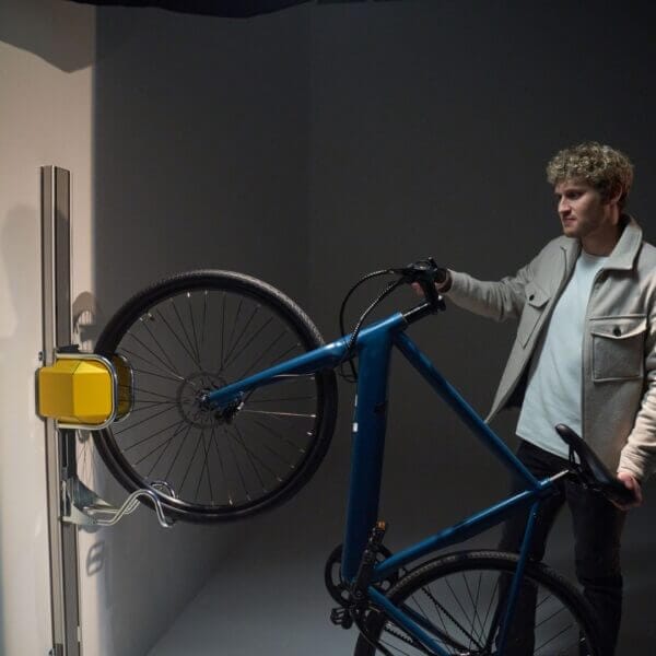 verticaal-fietsenrek-kopen Verticaal fietsenrek in kleur geel, voorzien van lift en muurbevestiging.