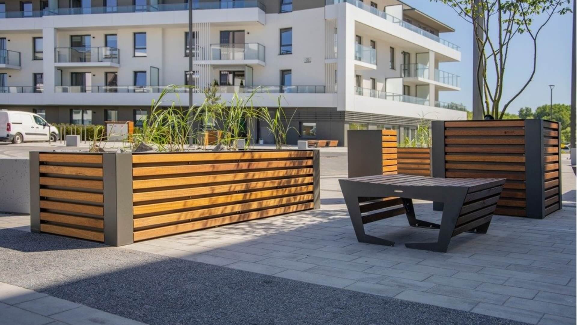 Plantenbak voor de openbare ruimte met moderne plantenbakken van hout en staal bij wooncomplex