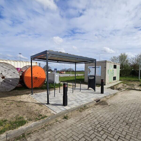 fietsoverkapping-openbare-ruimte-kopen Vrijstaande fietsoverkapping met sedumdak en fietsnietjes op een betegeld platform