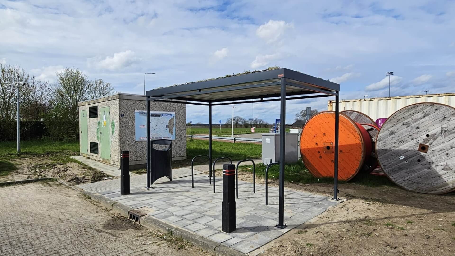 Rijwieloverkapping in RAL-7016 met sedumdak en voorzien van 4 fietsnietjes, bij een carpool locatie. 