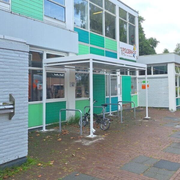 Witte rijwieloverkapping direct online aanschaffen Witte fietsoverkapping met fietsnietjes bij basisschool De Polderhof in Almere, door Umfeldt geplaatst