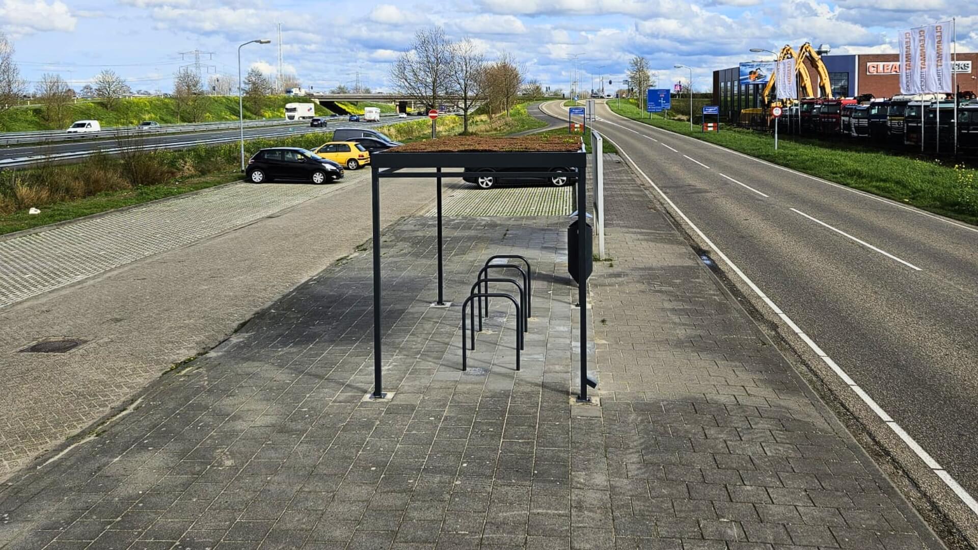 Fietsenstalling met sedumdak en fietsbeugels langs openbare weg, duurzame oplossing voor stallen van fietsen