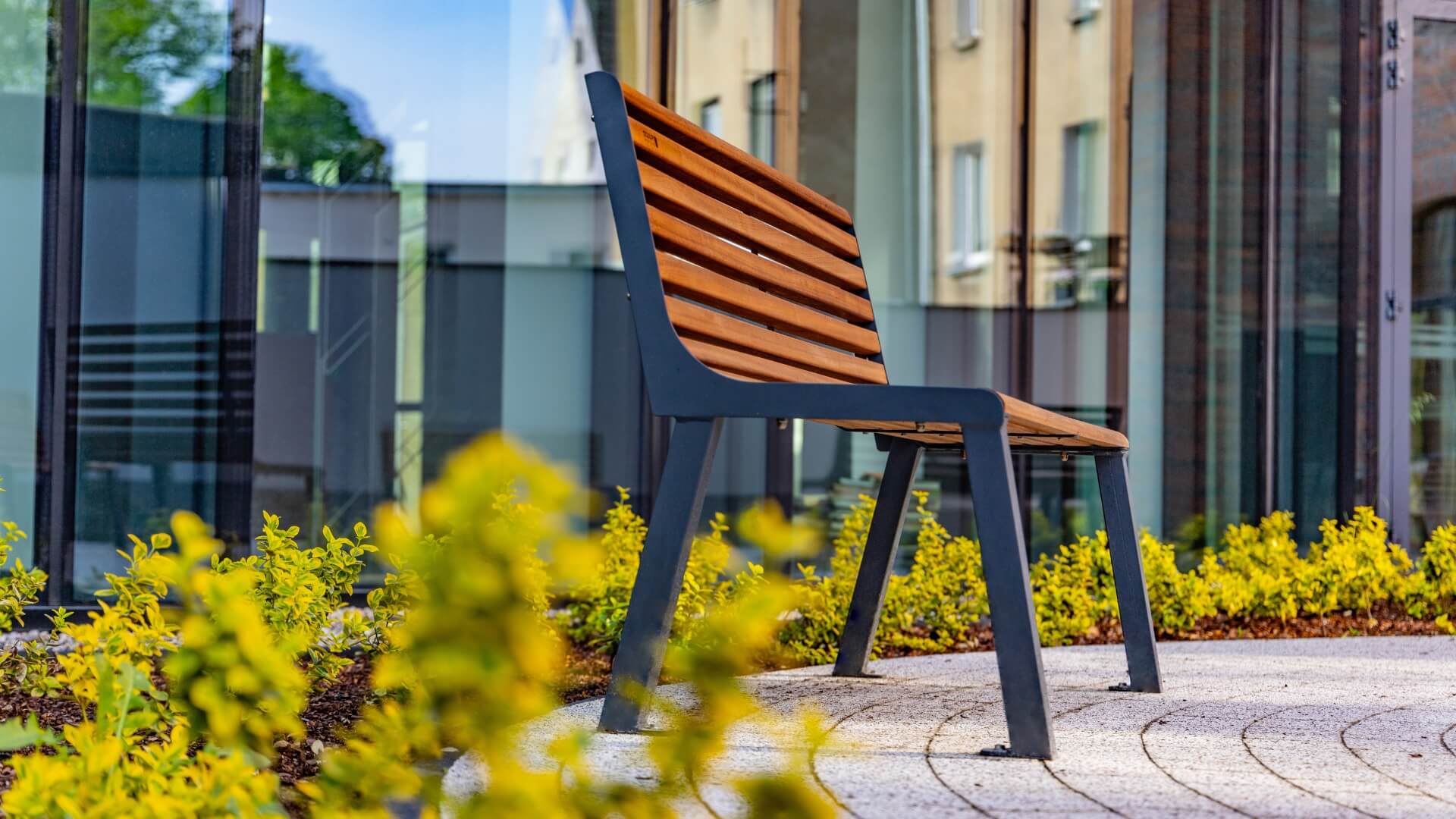 Moderne parkbank met houten latten en een stalen frame, perfect voor stedelijke en groene omgevingen. Onderstel is in diverse kleuren te bestellen.