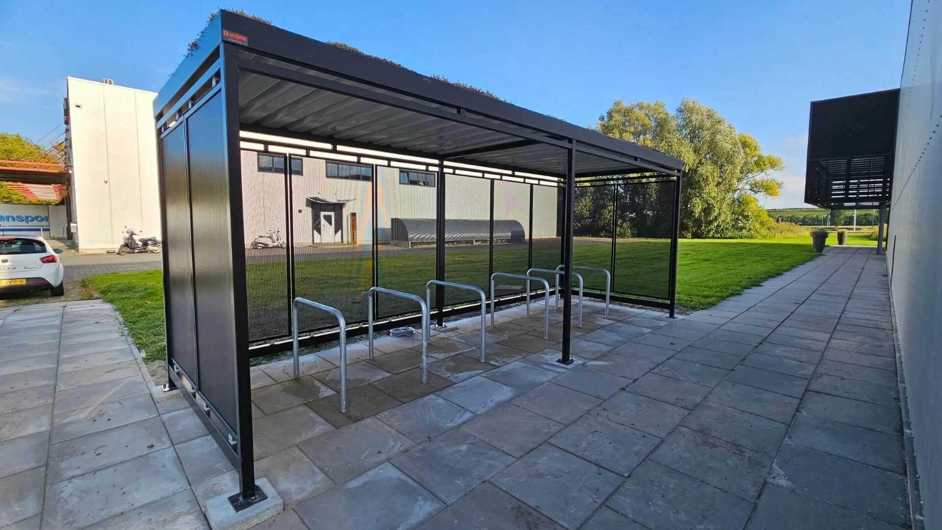 Fietsoverkapping van 6x2 meter met fietsaanleunbeugels en geperforeerde stalen wanden, geplaatst bij Online Veiling Meester in Groningen