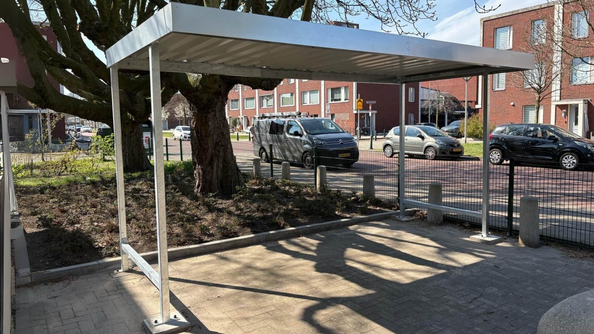 Prefab fietsenstalling met stalen frame en metalen dak geplaats bij een school
