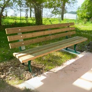 Houten buitenbank Verona in een groene parkachtige omgeving met betonnen verankering.