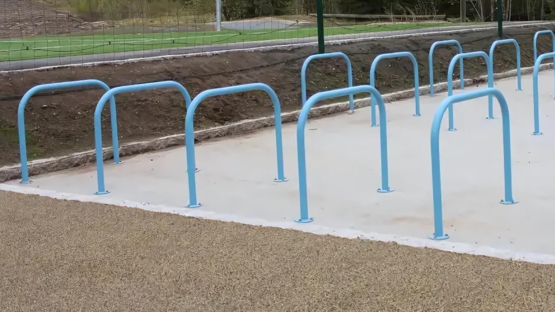 Lichtblauwe fietsnietjes op een betonnen ondergrond bij een sport locatie