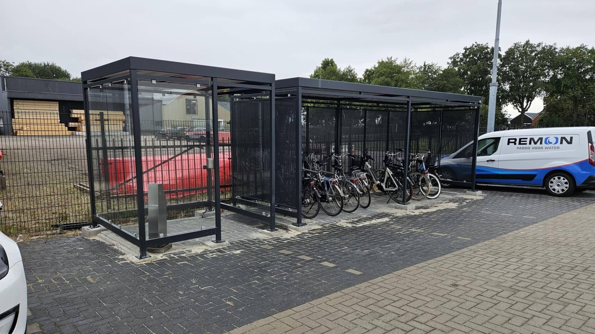Rookabri en fietsoverkapping van verzinkt staal met ESG glas en stalen panelen, geplaatst op locatie in Marum