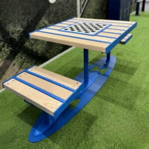 Schaaktafel voor buiten met een blauwe stalen frame en geplaatst op een groene ondergrond