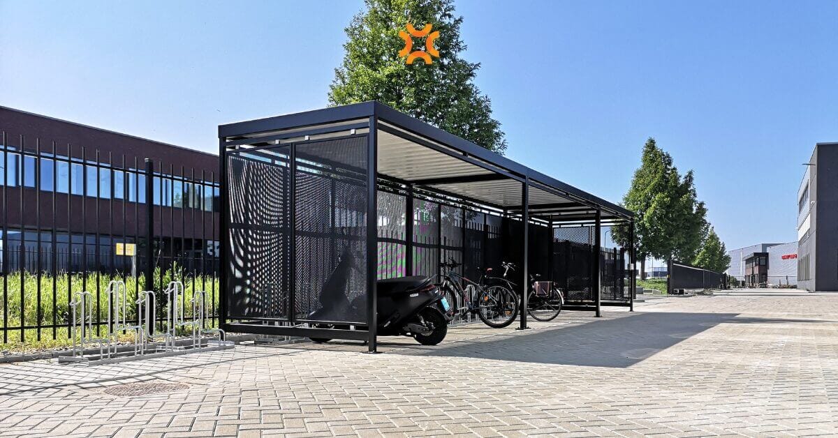 Fietsoverkapping van staal met daarin leasefietsen voor bedrijven. Lengte 12 meter en geplaatst op klinkers