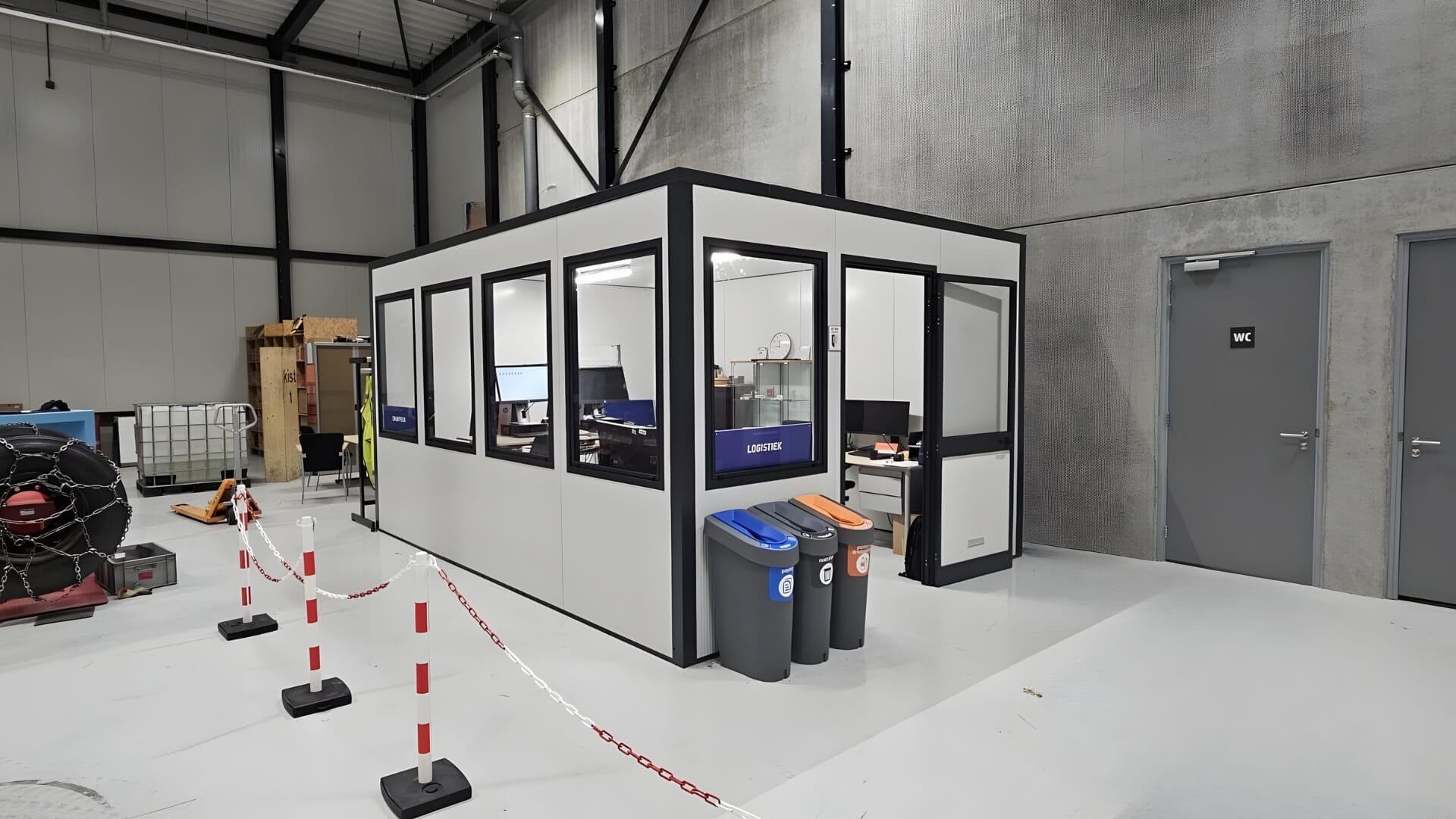 Modulaire prefab bureelunit geplaatst in magazijnhal met een maatvoering van circa 4x3 meter