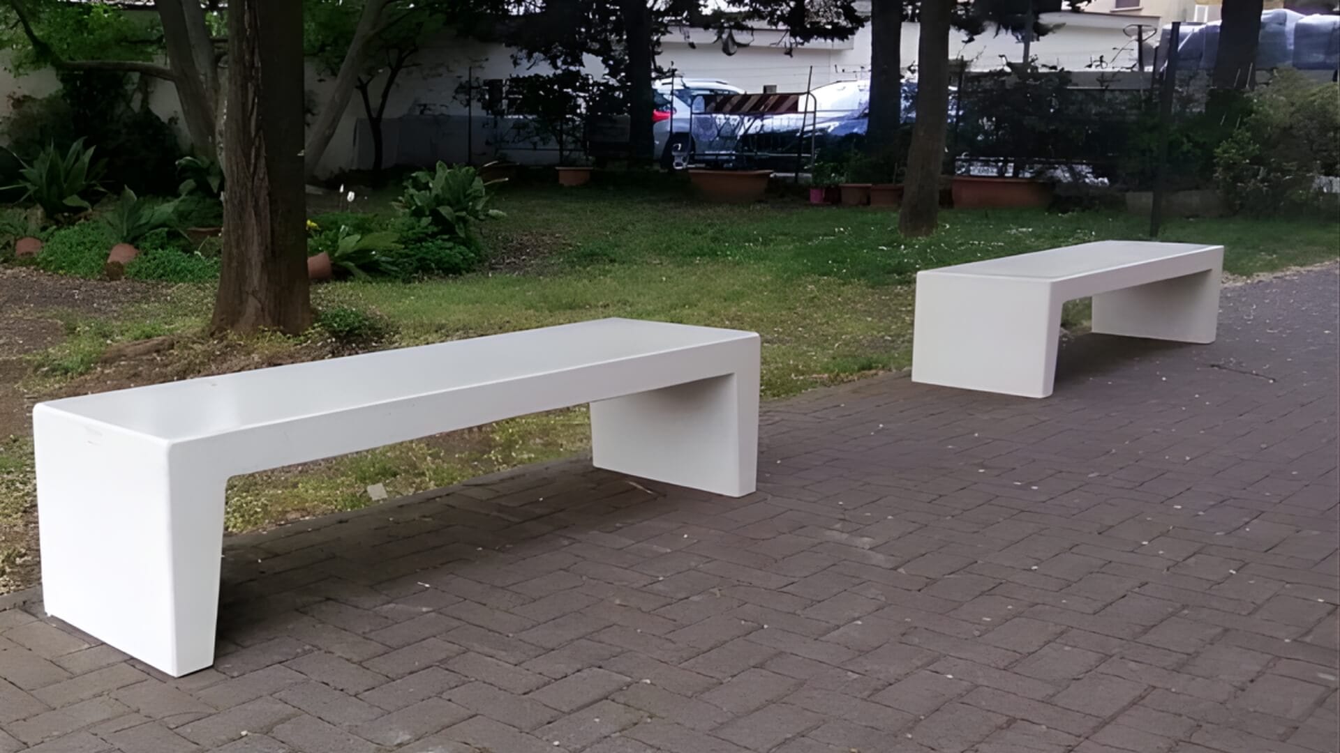 zitelement van beton geplaatst in de openbare ruimte, op tegels naast een grasveld