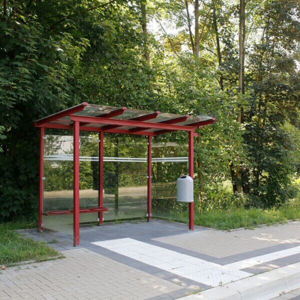 Bushokje rookabri in ral-kleur direct aanschaffen Rode rookabri met glazen wanden, ingezet als bushokje in een groene omgeving