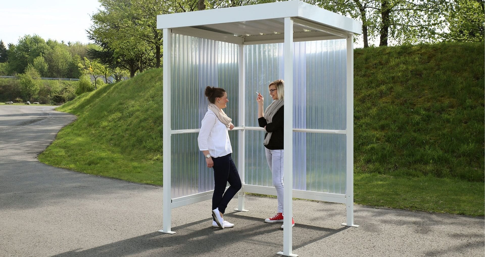 Kleine witte rokersabri met transparante wanden waarin twee personen staan te praten