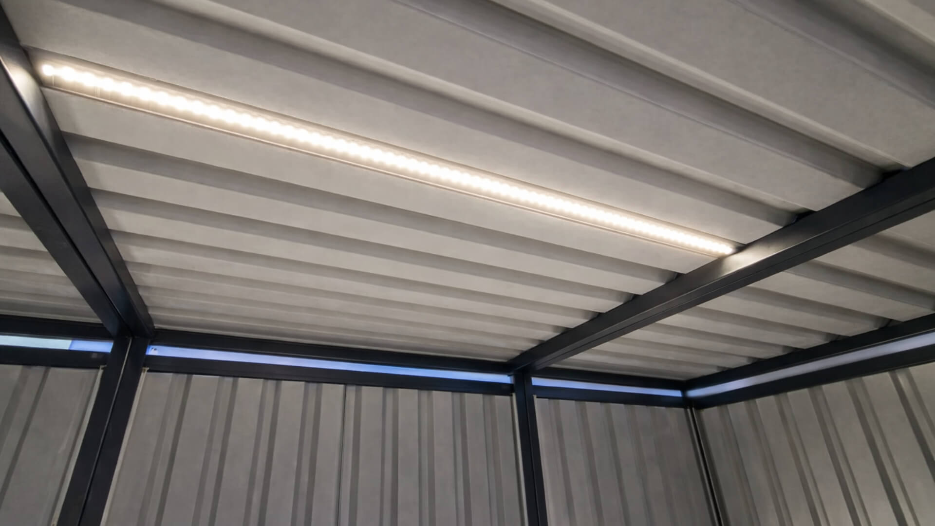 Rokersoverkapping met geïntegreerde LED verlichting in het dak, zichtbaar in een metalen rookruimte constructie