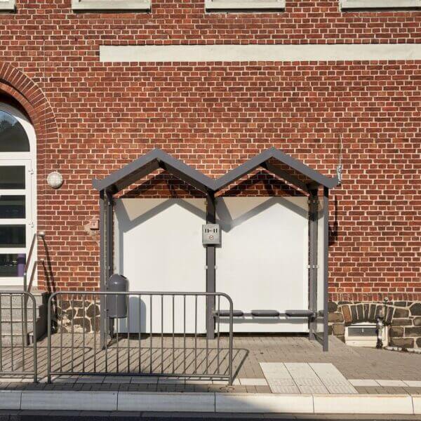 Rookhok 6 perosnone antraciet Umfeldt online aanschaffen Compacte rookoverkapping met zigzag dak tegen een bakstenen gebouw bij een trottoir